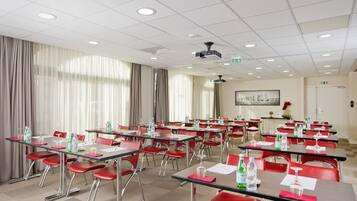 A conference room with tables, chairs, and a projector.