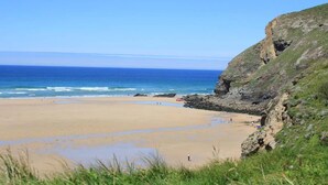 A coastal beach with a rocky cliff and a clear view of the ocean. - Bedruthan Hotel and Spa (Newquay)