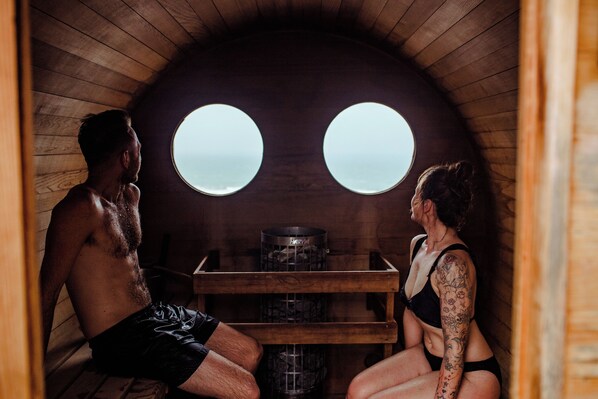 A sauna room with wooden walls and a bench.