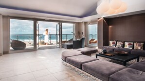 A spacious living room with a large glass door leading to a balcony overlooking the ocean. - Bedruthan Hotel and Spa (Newquay)