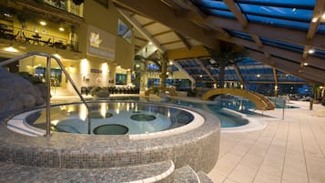 Relax by the pool surrounded by a circular deck and a central hot tub.
