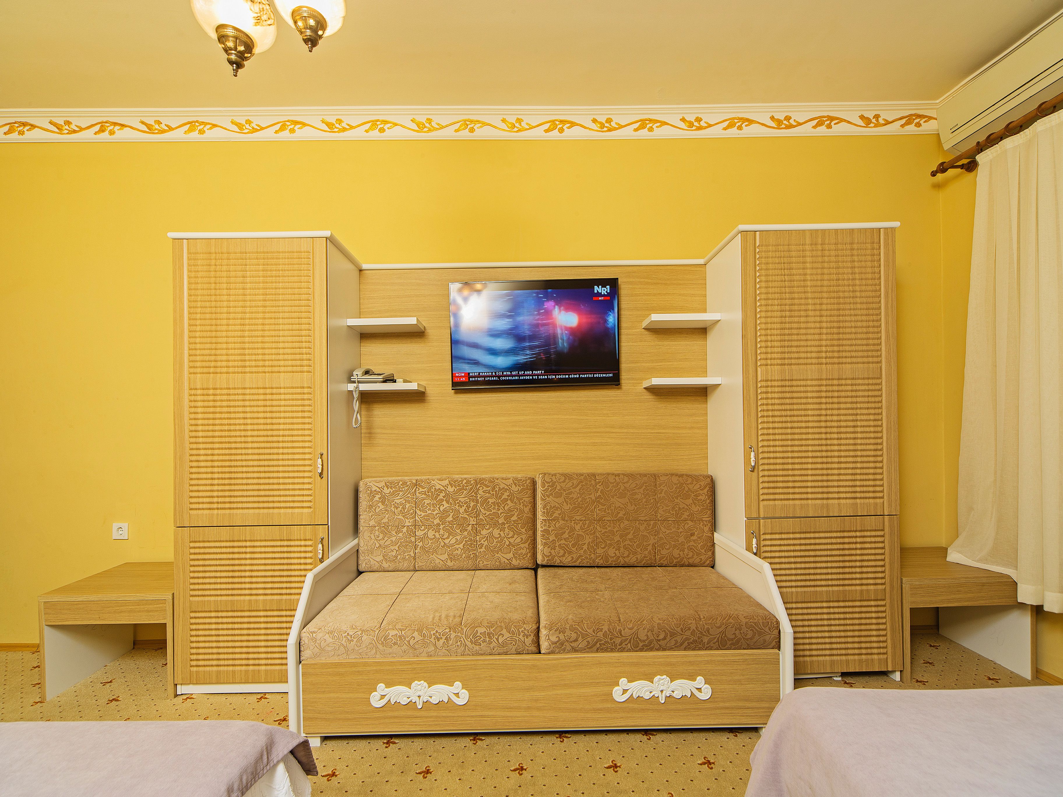 Une chambre à coucher avec un lit, une armoire, une télévision et une petite table.