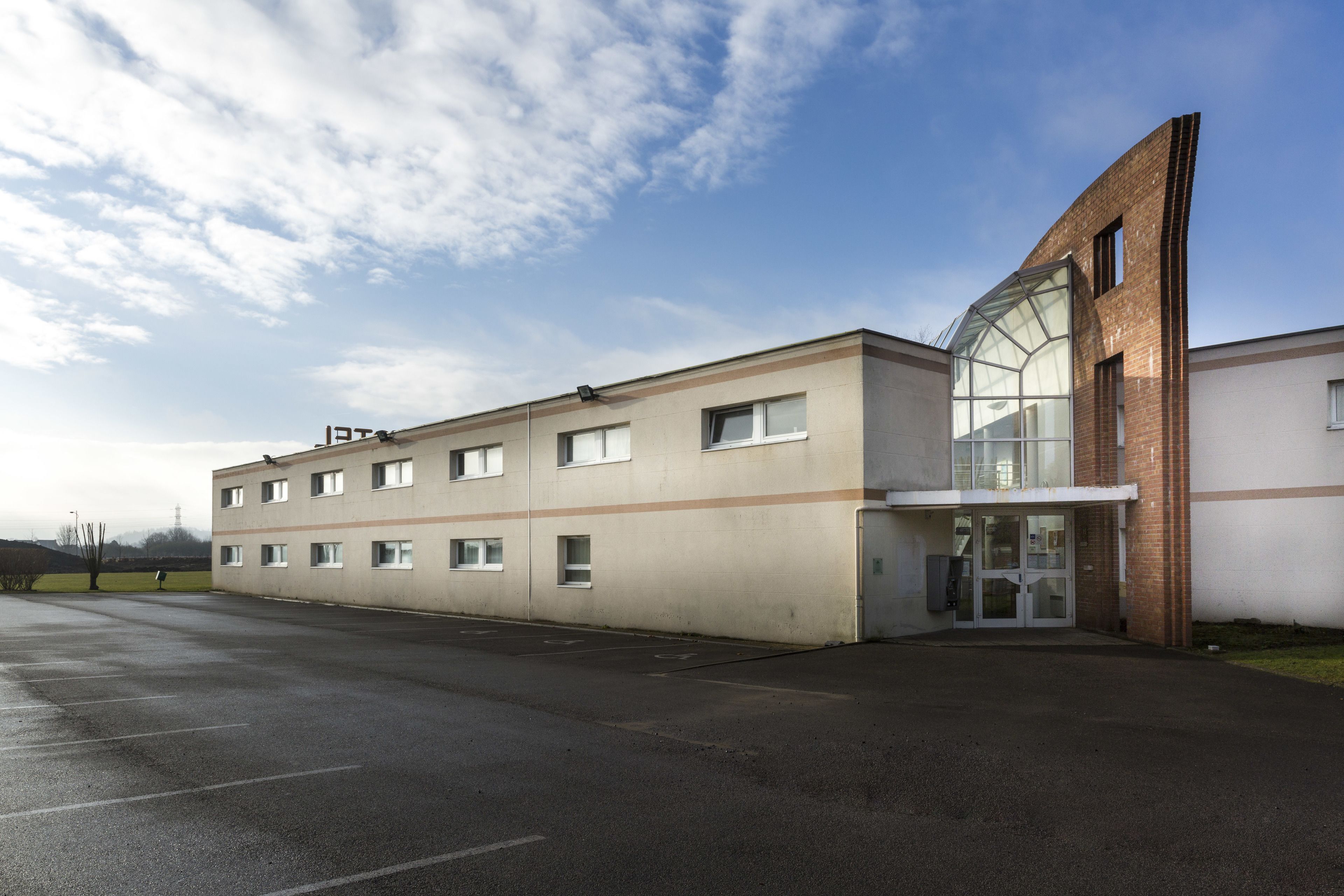 A modern building with a flat facade, large windows, and a glass entrance.