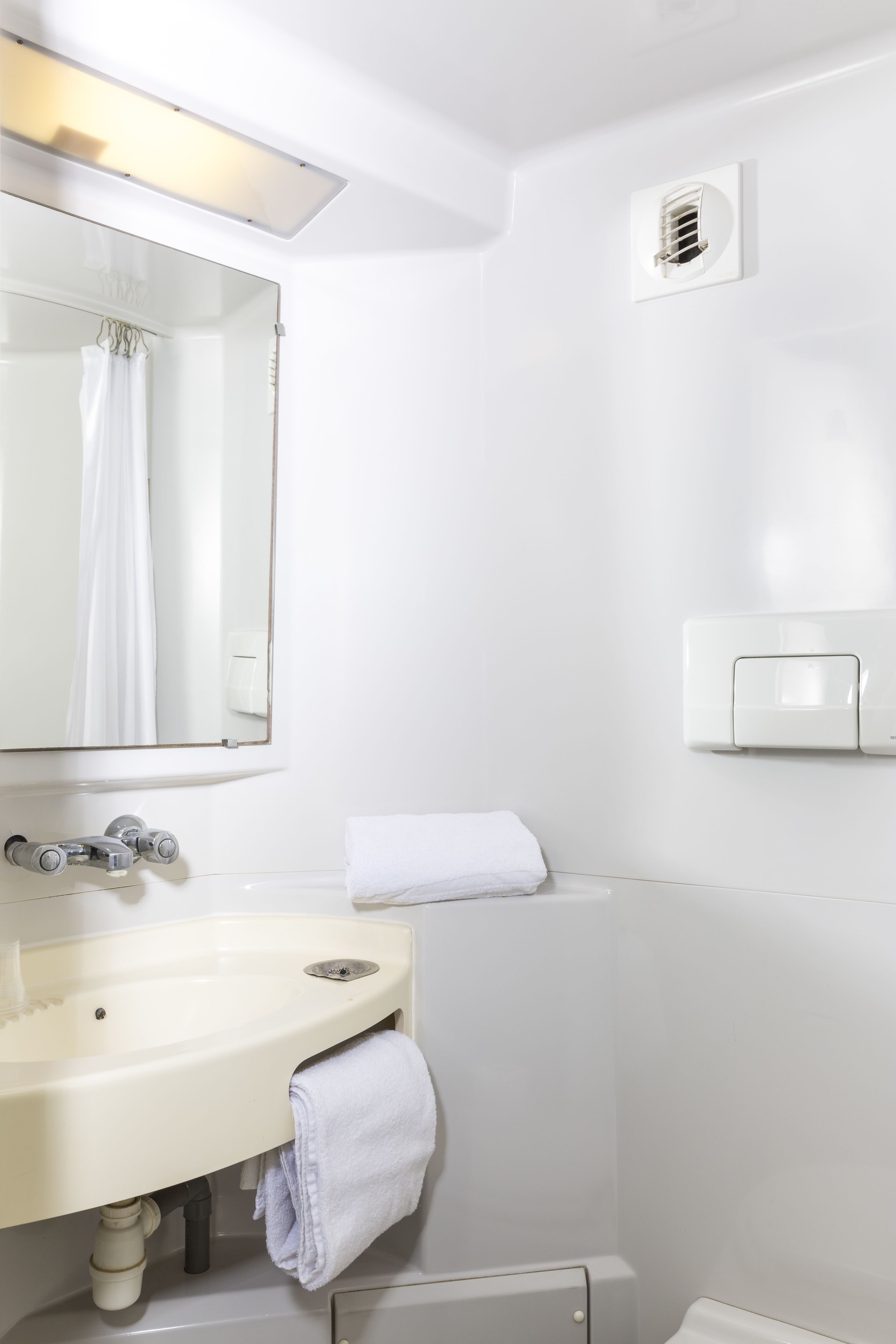 A bathroom with a white sink, mirror, and towel rack.
