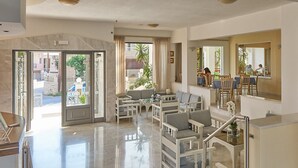 A spacious lobby with a seating area, a staircase, and a dining area. - Apollon Hotel Apartments (Rethymno)