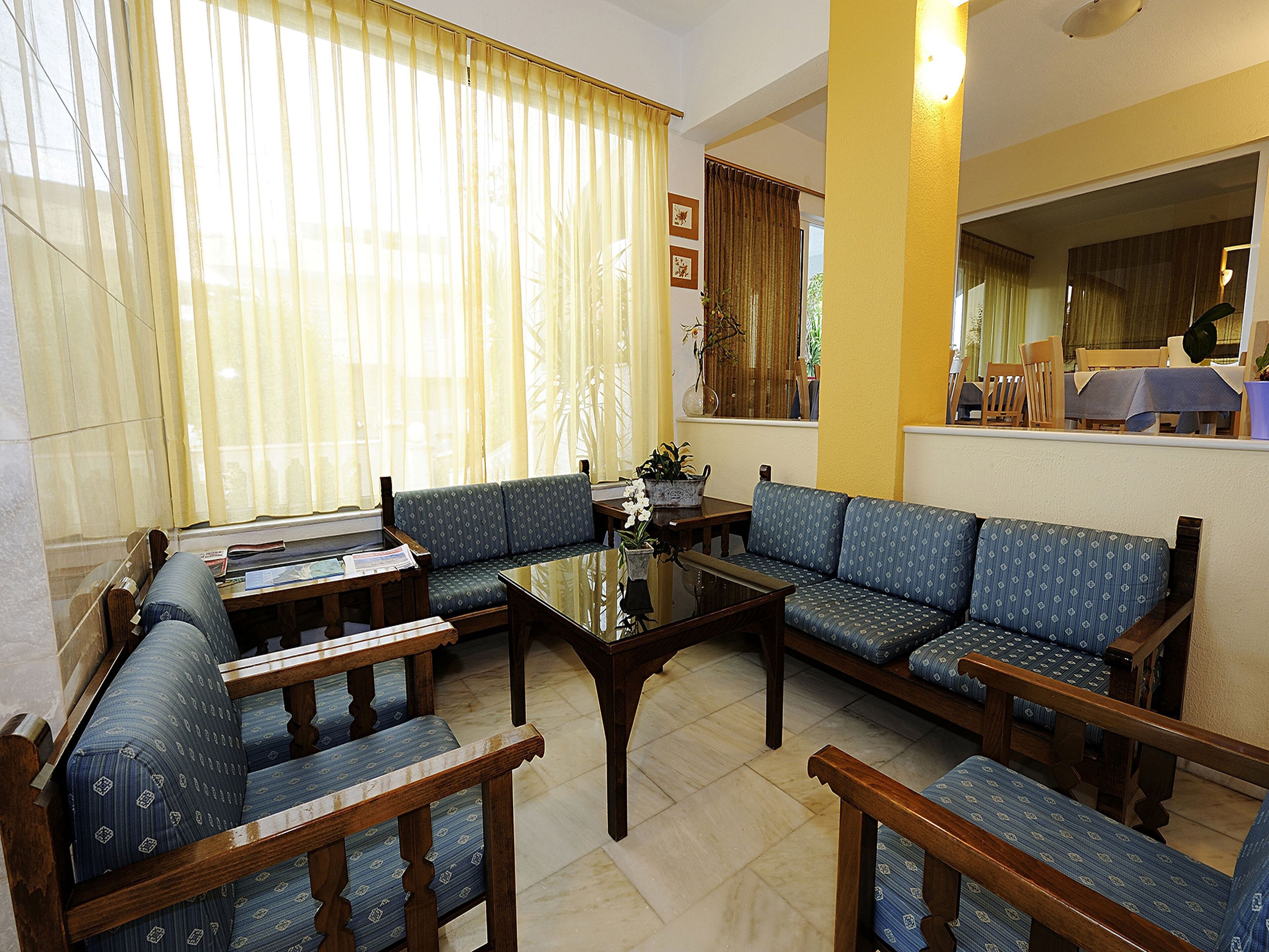 A room with a sofa set, a coffee table, and a dining table with chairs.