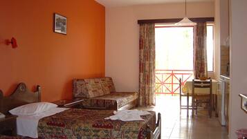 Une chambre d’hôtel avec deux lits, un coin repas et une vue sur l’extérieur.