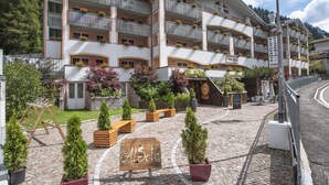 A multi-story hotel with balconies, a sign reading "Al Sole", and a cobblestone courtyard. - Al Sole Clubresidence (Canazei)