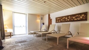 A room with wicker chairs, a stone floor, a wooden wall art piece, and a lamp. - Al Sole Clubresidence (Canazei)