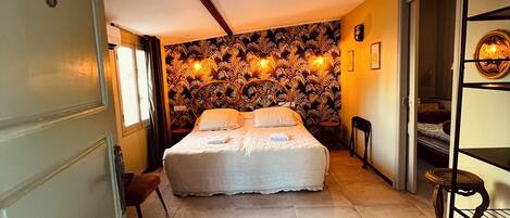 Un dormitorio con cama, una silla, una mesita y una puerta con un número.
