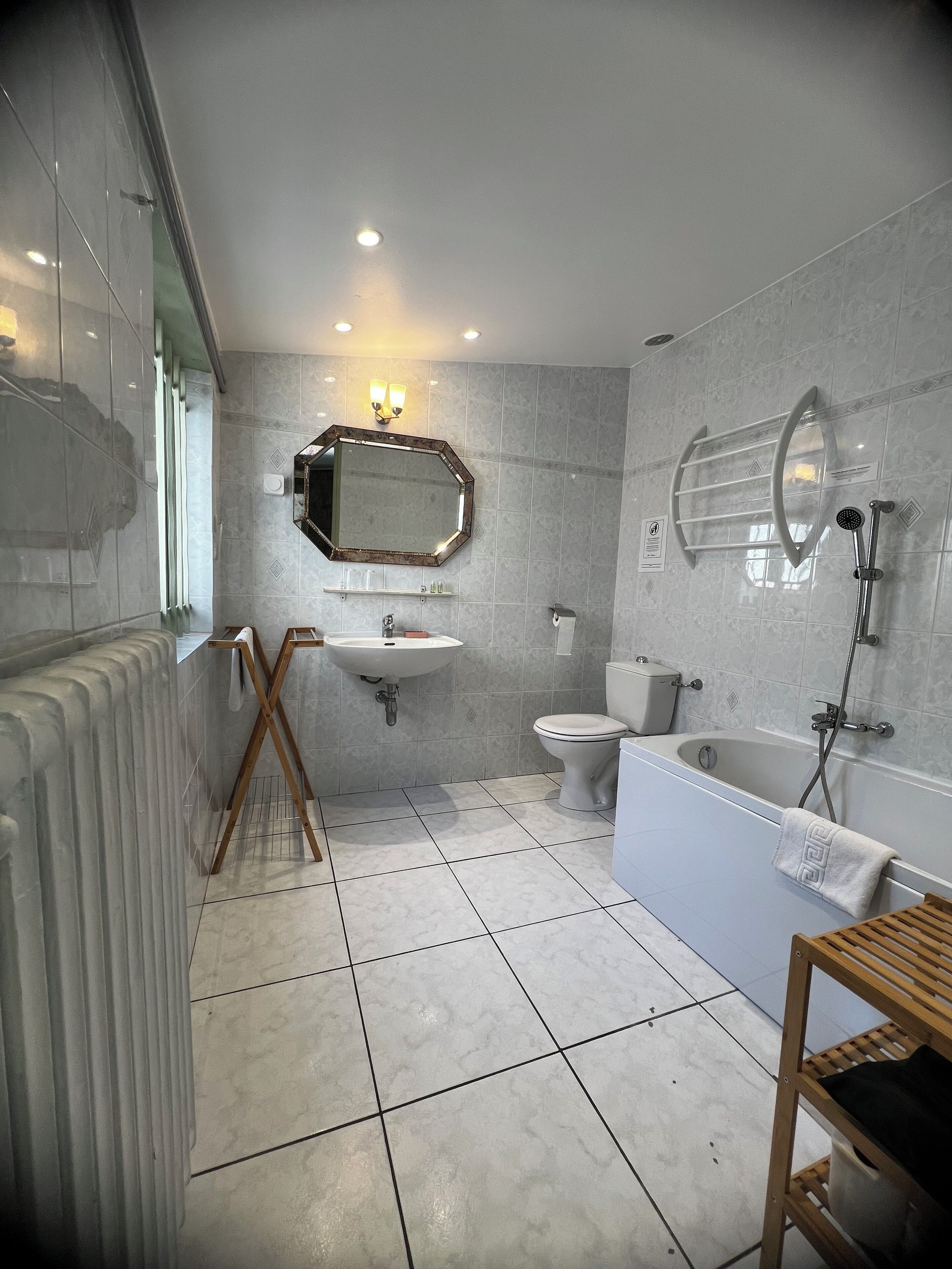 Een moderne badkamer met een bad, toilet en wastafel.