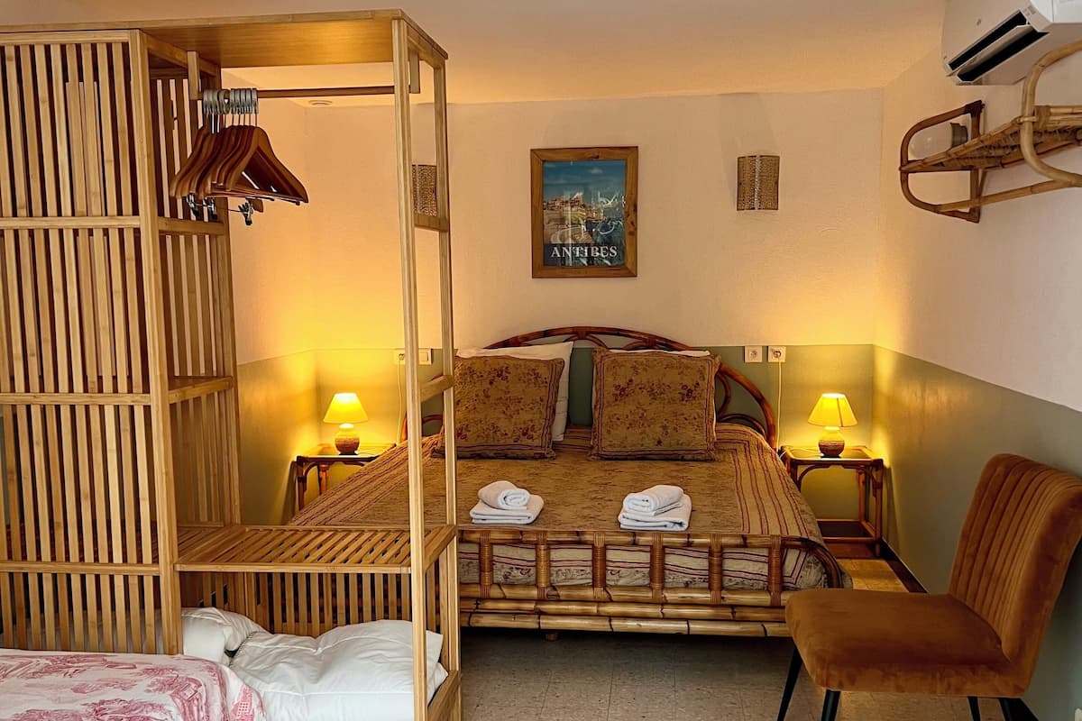 Ein Zimmer mit einem Etagenbett, einem Einzelbett, einem Stuhl und einem Nachttisch mit Lampen.