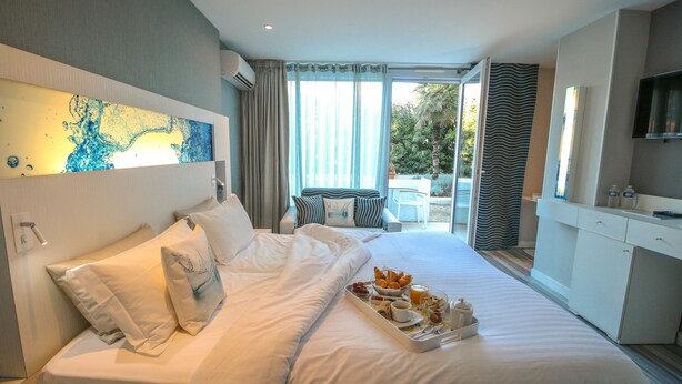 Une chambre d’hôtel avec un grand lit, un plateau de petit-déjeuner, une télévision et une vue sur l’extérieur.