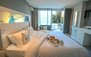A hotel room with a large bed, a breakfast tray, a TV, and a view of the outdoors. - Hotel Josse (Antibes)