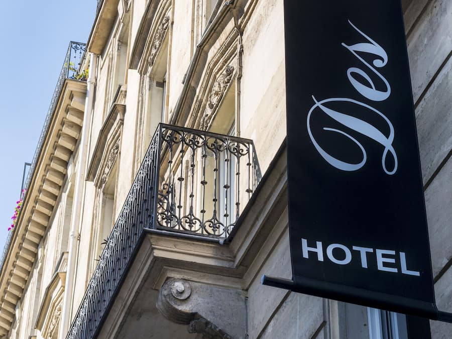 A hotel sign with the name "Des Ecrivains" on a building facade.