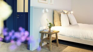 Una camera da letto con un letto, un comodino, una lampada e una mensola a parete.
