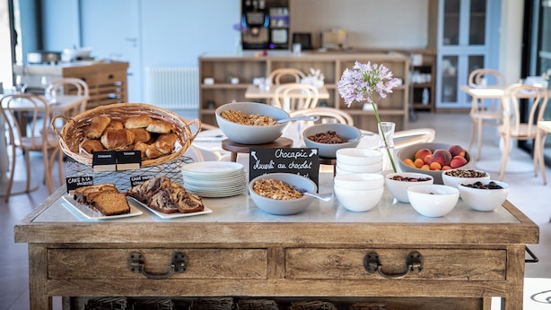Un buffet della colazione con diversi dolci, frutta e granola.