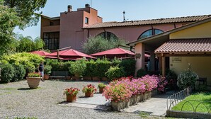 Une cour intérieure avec un bâtiment, des sièges en plein air et des plantes en pot.