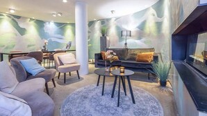 Una sala de estar moderna con techo curvo, un conjunto de sofás, una mesa de centro y una chimenea.
