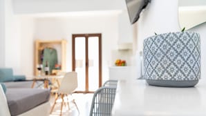 A modern living room with a sofa, chairs, and a patterned vase on a table. - Depis Place & Apartments (Naxos)