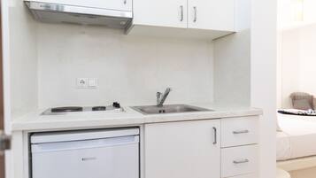 Una cocina compacta equipada con lavavajillas, pileta y cocina.