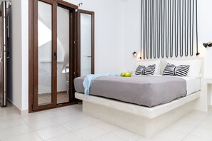 A bedroom with a bed, a sliding door, a wall-mounted light fixture, and a bedspread.