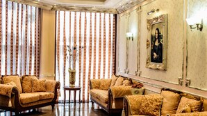 A luxurious lobby with ornate sofas, a chandelier, and a large painting on the wall. - Hotel Karolina (Sunny Beach)