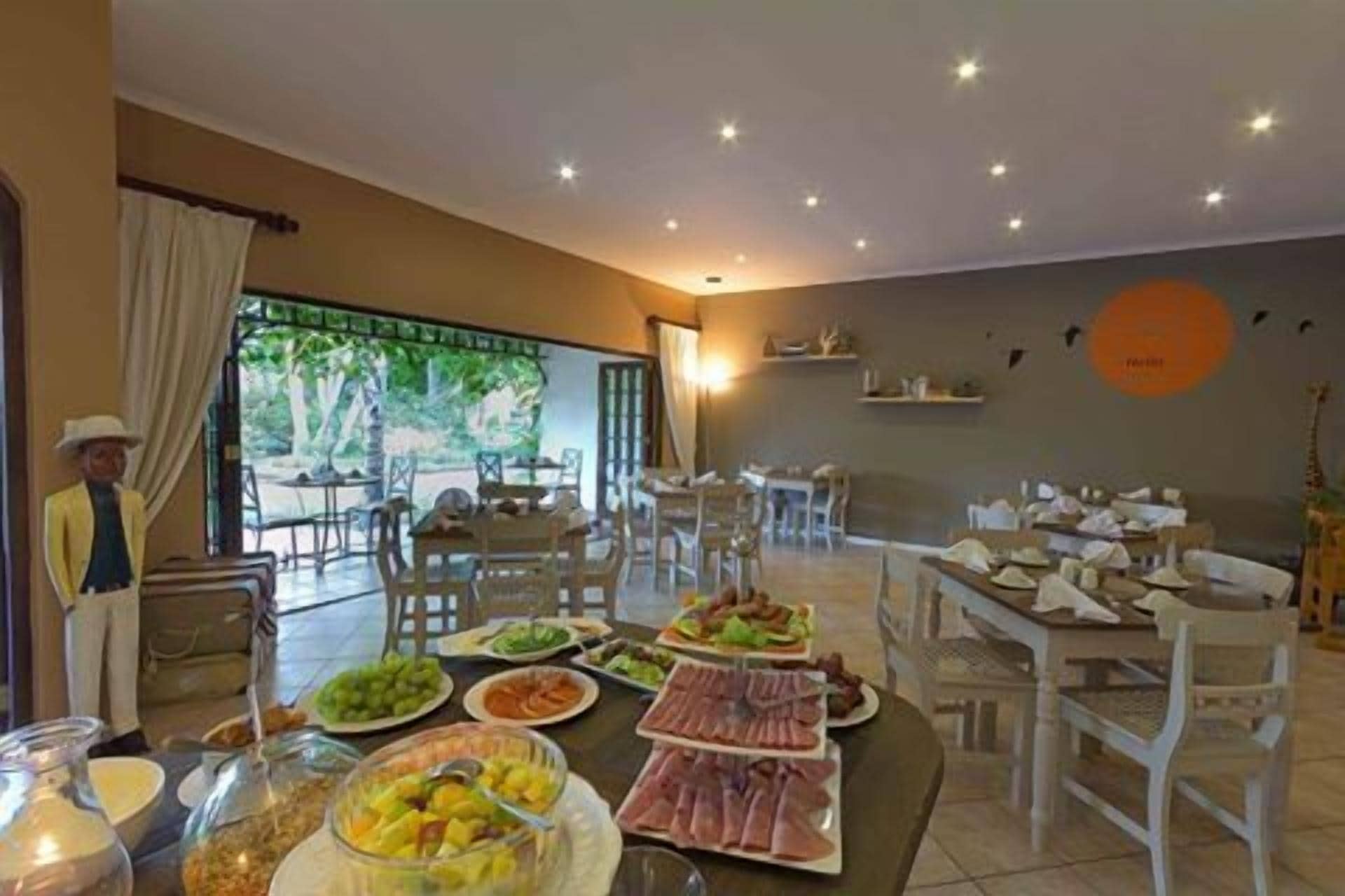 Een eetgedeelte met meerdere tafels voor een buffet, met een verscheidenheid aan gerechten.