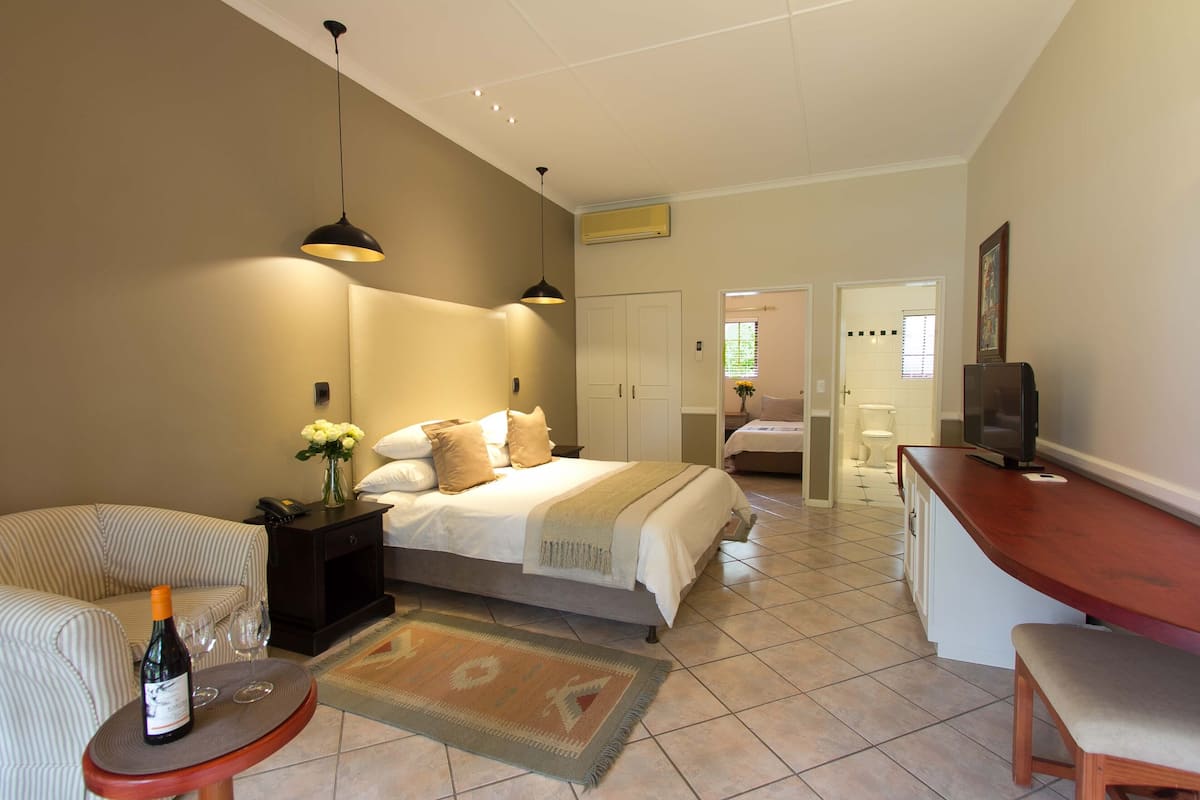 A bedroom with a bed, bedside table, and a TV.