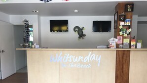 Un mostrador de recepción con un letrero que dice "Whitsunday On The Beach".