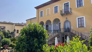 A yellow building with arched windows and a balcony.