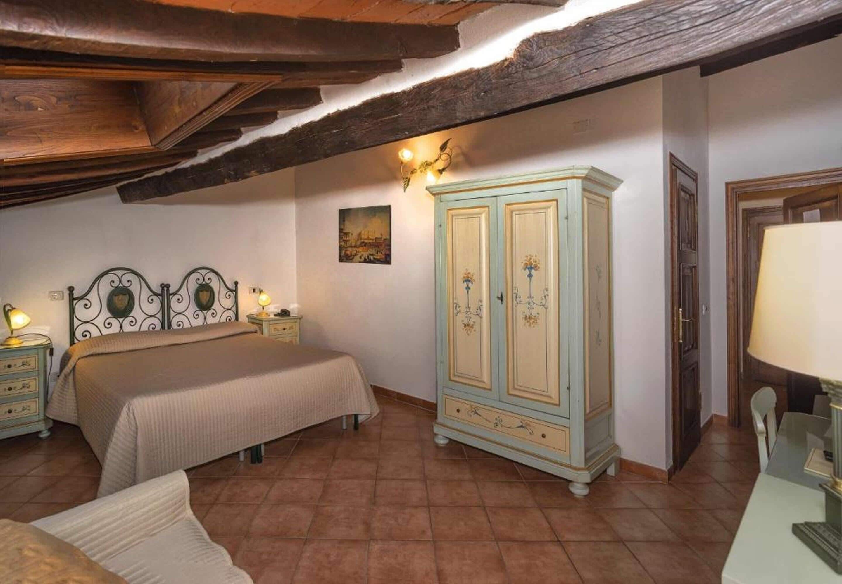 A bedroom with a bed, bedside tables, a wardrobe, and a lamp.
