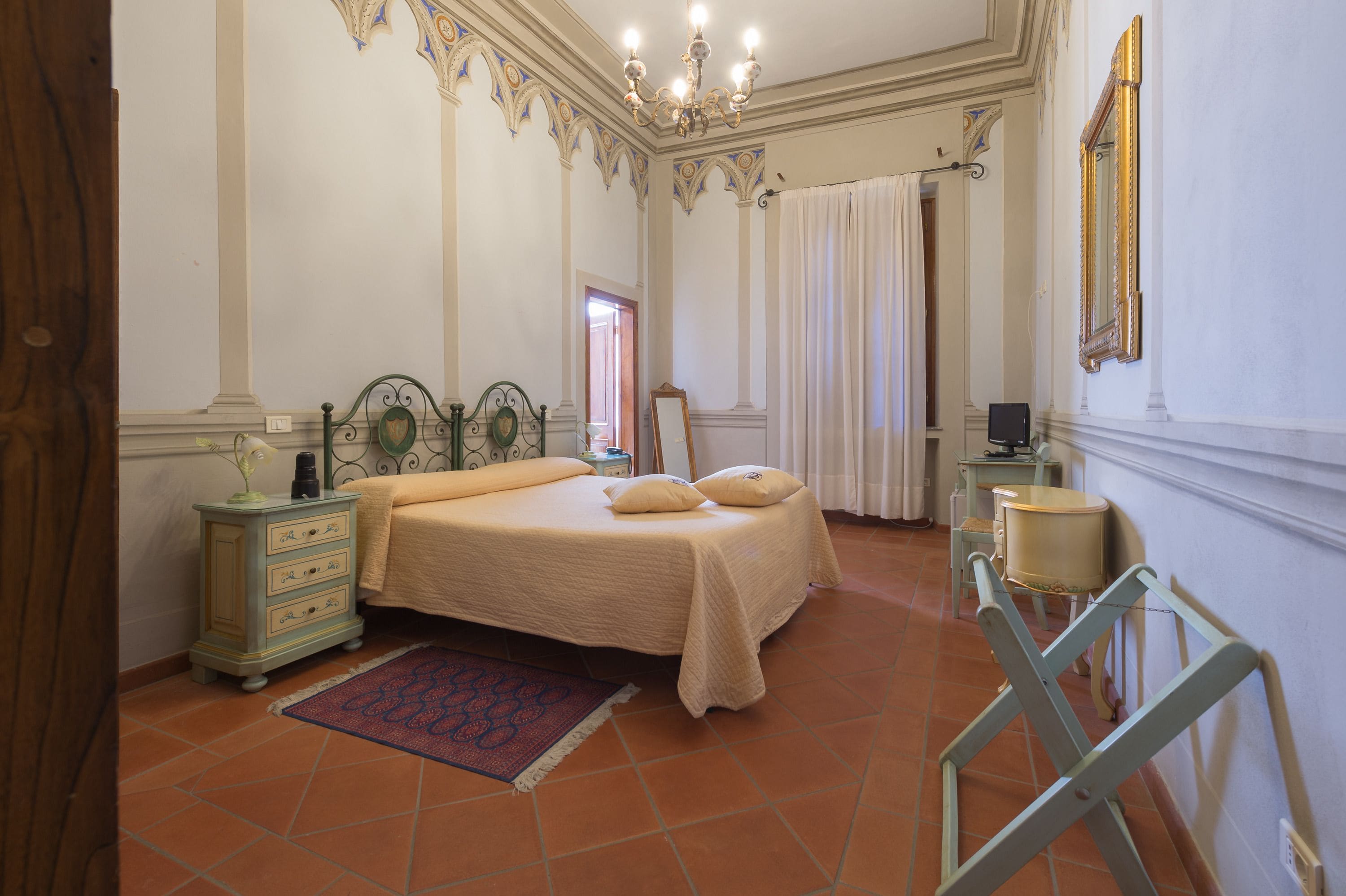 Ein Schlafzimmer mit Bett, Schminktisch und Spiegel.