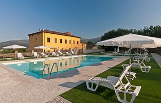 Una piscina al aire libre de temporada, sombrillas
