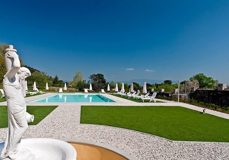 Una piscina al aire libre de temporada, sombrillas
