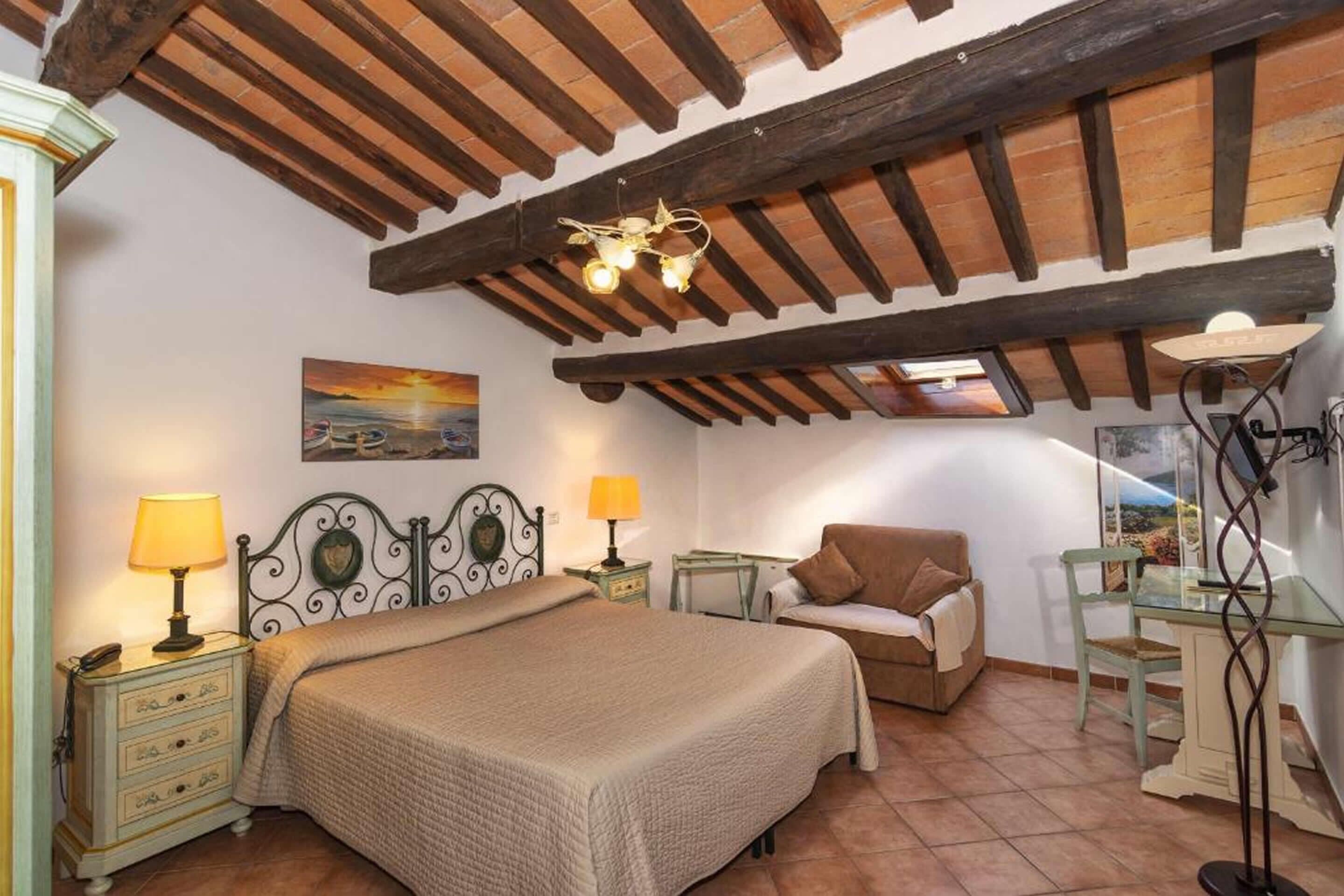 Une chambre à coucher avec un lit, une chaise, un bureau et un tableau accroché au mur.
