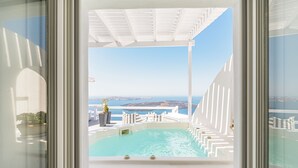 Una piscina con vistas al mar y una estructura arquitectónica blanca.