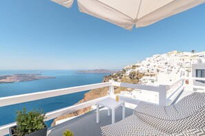 A balcony with a view of the sea and white buildings. - Avianto Suites (Santorini)