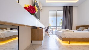 Et moderne hotelværelse med to senge, et skrivebord og et stort vindue.