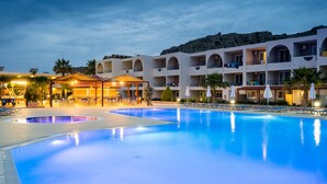 Et hotel med swimmingpool, flere balkoner og udendørs siddeområder.