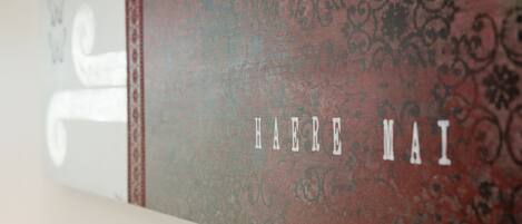 A wall with a decorative pattern and the text "HAERE MAI" in white letters.