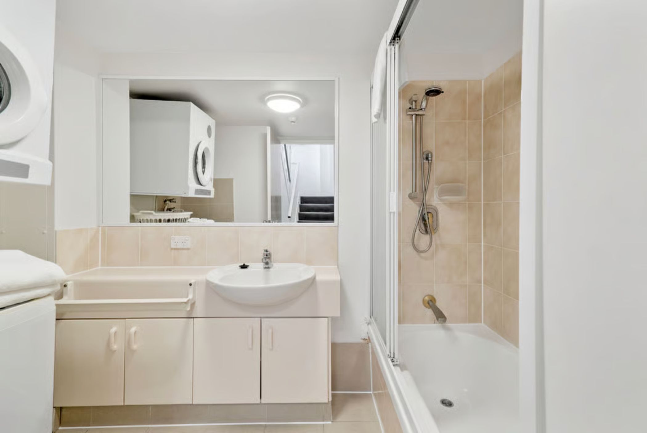 A modern bathroom with a sink, mirror, and shower.