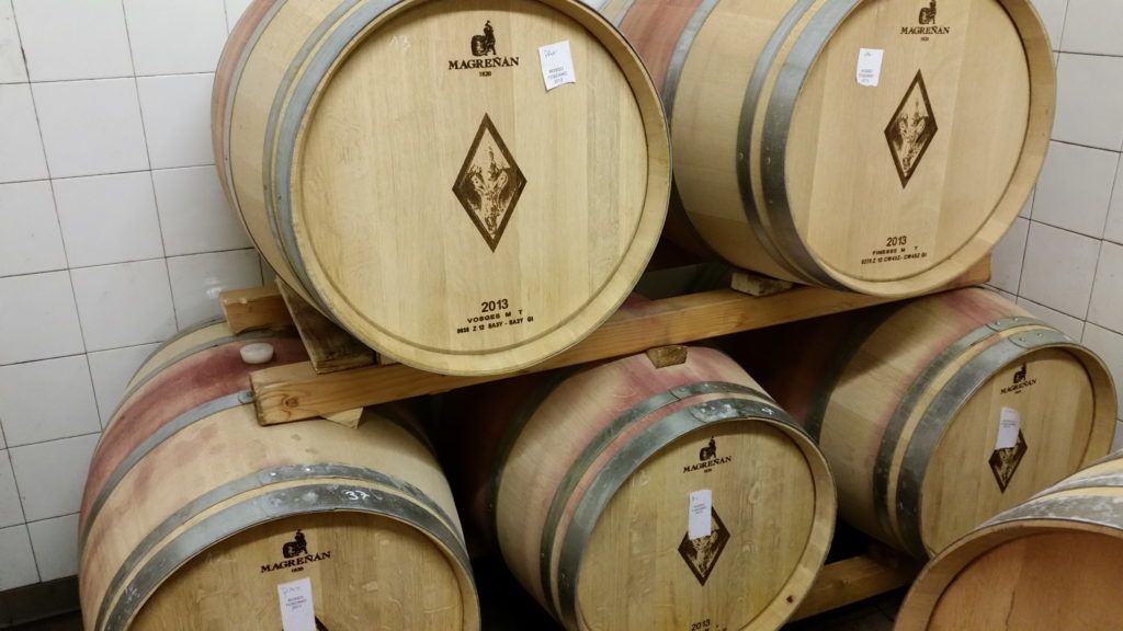 Barricas de vino de madera apiladas sobre una estructura de madera.
