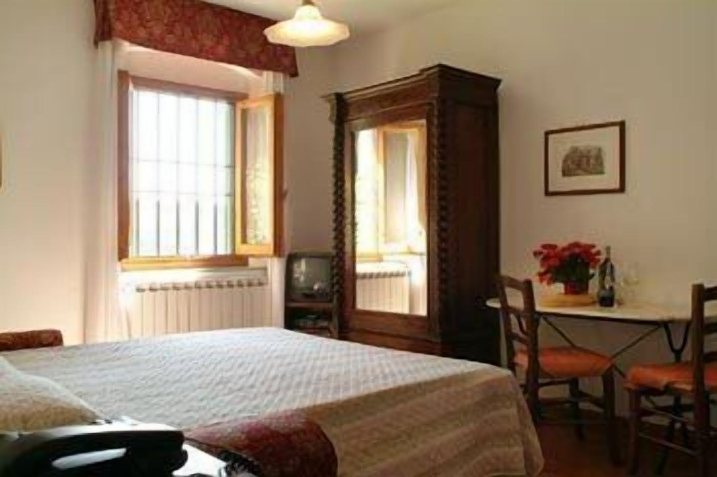 A bedroom with a bed, a desk, and a chair.