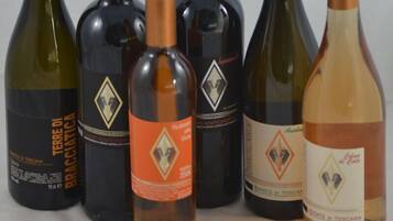 Six bouteilles de vin de tailles et de couleurs différentes, chacune ayant une étiquette et une marque distinctes.