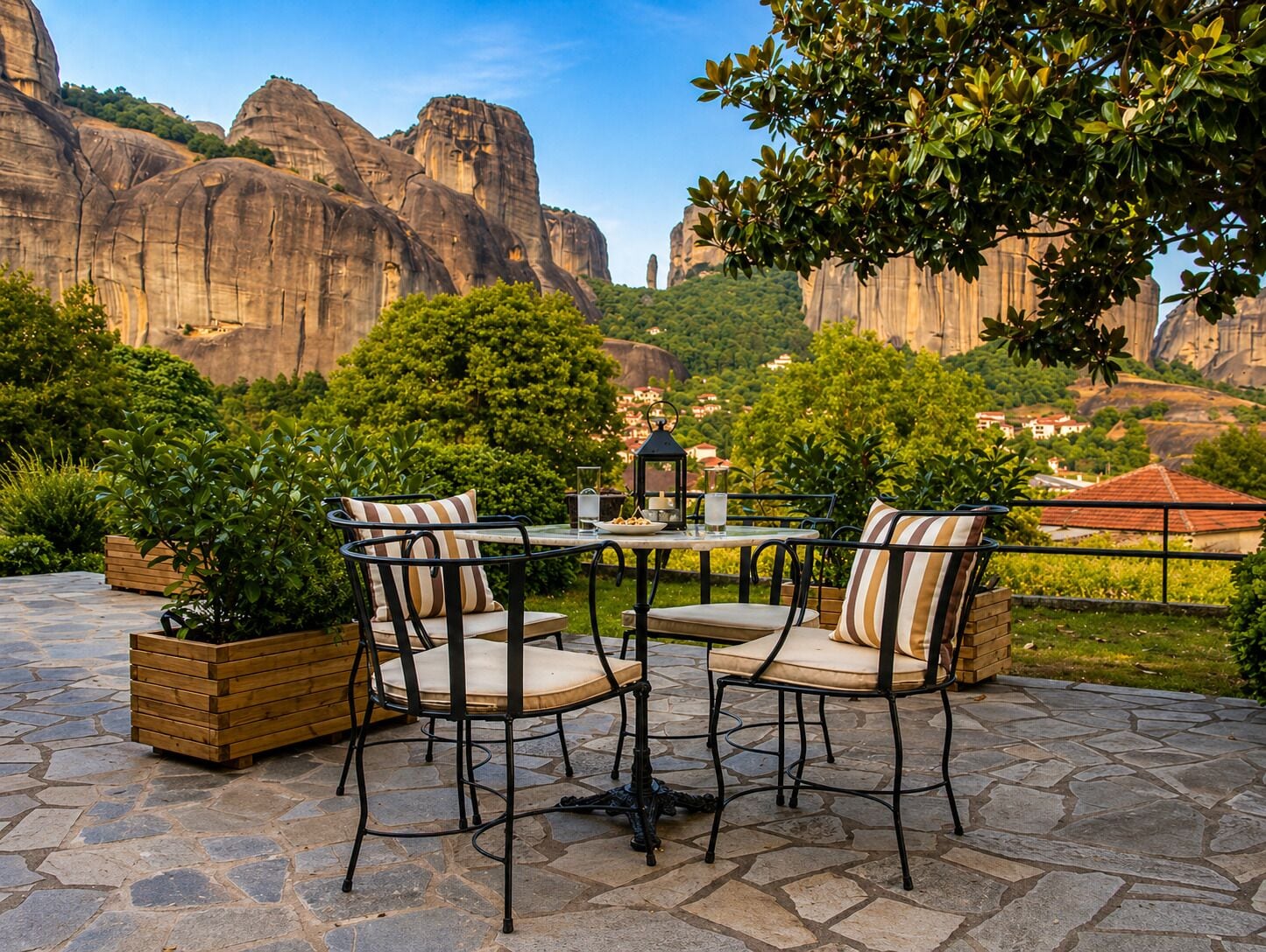 Une terrasse extérieure avec une table et des chaises, entourée d’un sol en pierre et de plantes en pot.