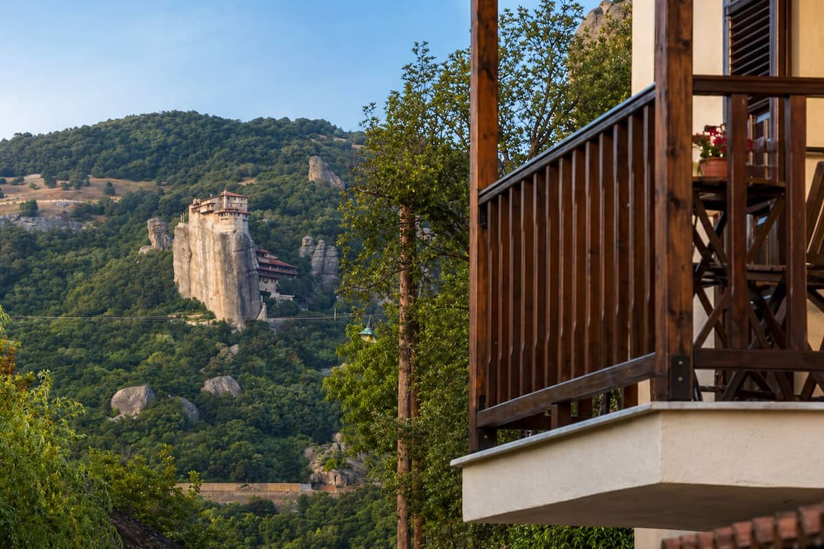 Ein Balkon mit Blick auf eine große Felsformation und ein Gebäude auf einem Hügel.