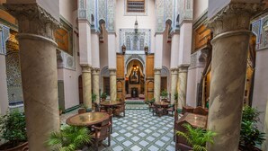 A courtyard with marble columns, tiled flooring, and potted plants. - Dar Victoria (Fes)
