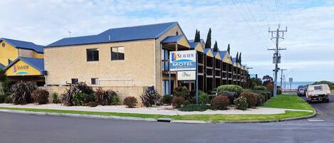 A Seaview Motel with a blue roof and beige walls, featuring a reception area and multiple floors.