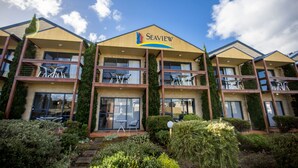 A Seaview hotel with multiple balconies, large windows, and a well-maintained garden. - Seaview Motel and Apartments (Apollo Bay)